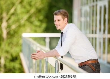 Young man dressed formal resting at office balcony.
