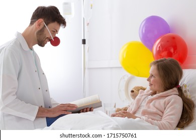 Young Man Dressed Up As A Hospital Clown Reading A Book To A Girl