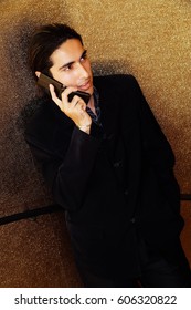 Young man dressed in suit, using mobile phone
