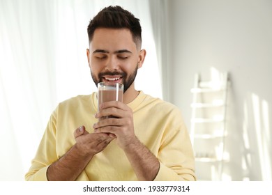 Young Man Drinking Chocolate Milk In Room