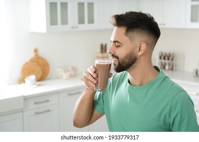 Young Man Drinking Chocolate Milk In Kitchen