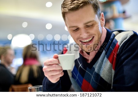 Young man drinking a coffee at the cafe