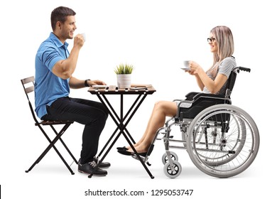 Young Man Drinking Coffee With A Disabled Woman In A Wheelchair Isolated On White Background
