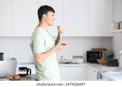 Young man drinking coffee in kitchen - Powered by Shutterstock