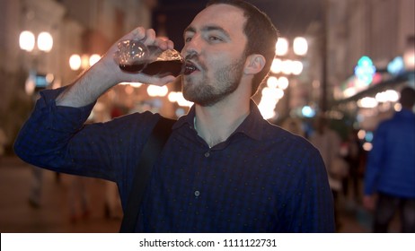 Young Man Drinking Coke At Night City