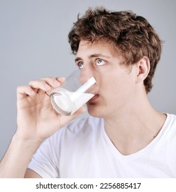 Young man drinking a glas of milk - Shutterstock ID 2256885417