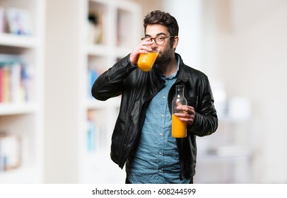 Young Man Drinking An Orange Juice