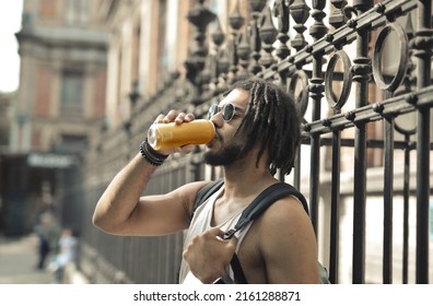 Young Man Drinks A Beer On The Street