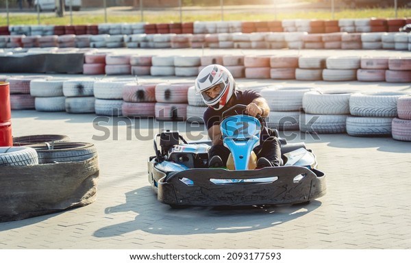 A young man drives\
a go kart at circuit