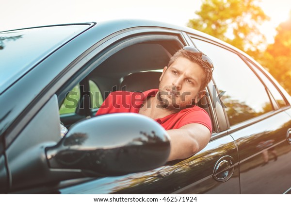 The young man driving the car angry, stuck in a\
traffic jam