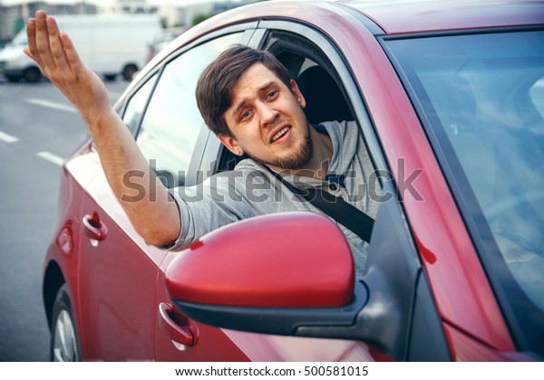 The young man driving the car angry, stuck in a
traffic jam
