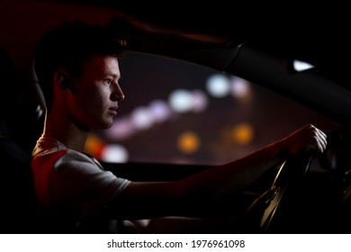 Young Man Driving Car At Night