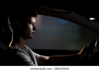 Young Man Driving Car At Night