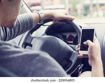 Young Man Driving Car And Using Mobile Phone