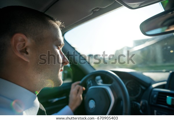 young man driving an\
expensive car