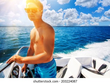 Young Man Driving A Speedboat