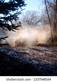 Young Man Driving Through Mud With Four Wheeler In Dirt Track