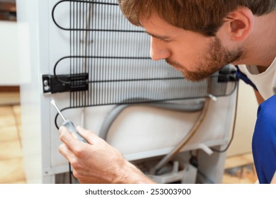 Young Man During Fridge Repair