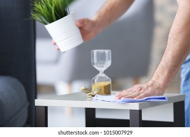 Young Man Dusting Table While Cleaning Flat, Closeup