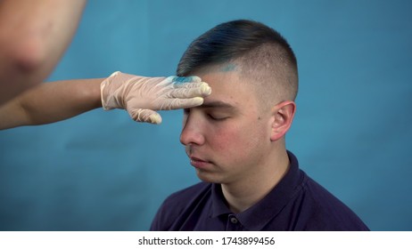 The Young Man Dyed His Hair Blue. An Alternative Person Is Dyed With Temporary Spray Hair Dye. On A Blue Background