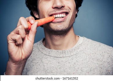 Young Man Eating A Carrot