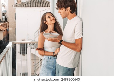 Young man eating cereal  with his girlfriend, on the terrace of Athens apartment - Powered by Shutterstock