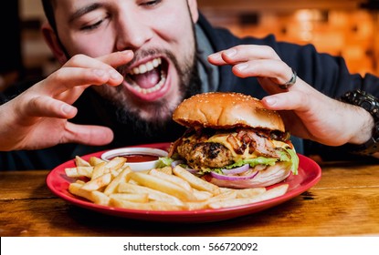 Young man eating a cheeseburger. Restaurant