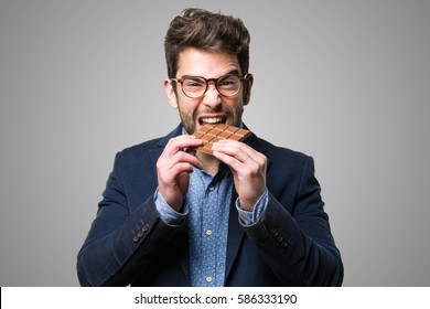 Young Man Eating A Chocolate Bar