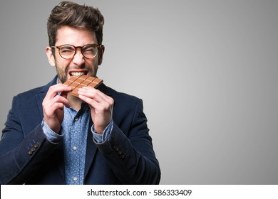 Young Man Eating A Chocolate Bar