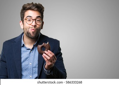 junger Mann, der einen Schokoladendontie isst