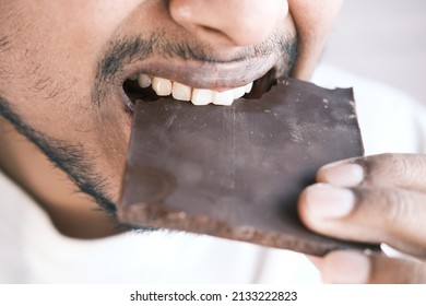 Young Man Eating Dark Chocolate Close Up 