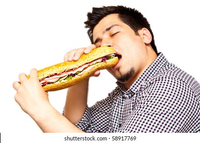 Young Man Eating A Freshly Made Sub Meat Feast Sandwich Isolated On White