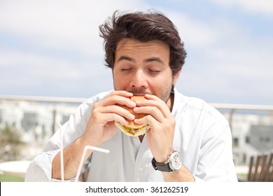 Young Man Eating A Hamburger