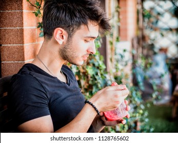 Young Man Eating Ice Cream While Sitting Outdoor On Terrace At Home In A Summer Day