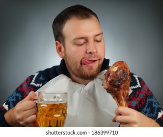 Young Man Eating Meat And Drinking Beer