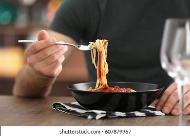 Young Man Eating Pasta At Table, Closeup