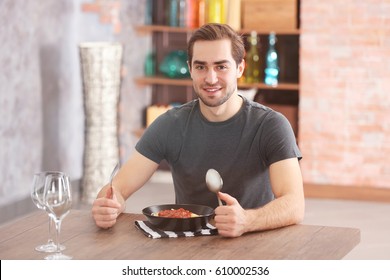 Young Man Eating Pasta At Table