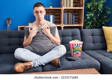 Young Man Eating Popcorn Depressed And Worry For Distress, Crying Angry And Afraid. Sad Expression. 