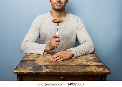 Young Man Eating Sausage