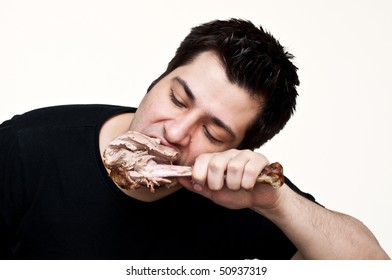 Young Man Eating A Turkey Leg Isolated On White