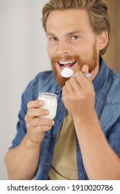 A Young Man Eating A Yogurt