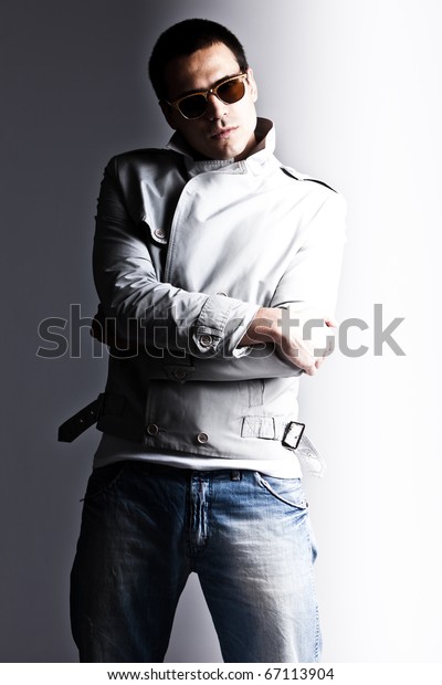 young man in elgant jacket and jeans divided with\
dark and light,  studio\
shot
