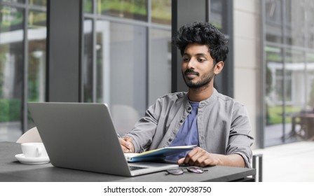 Young Man Employee Using Laptop Computer, Businessman Working In Office. Indian Student Looking At Laptop. Casual Business, Freelance Work, Distance Studying, Meeting Online, Modern Lifestyle 