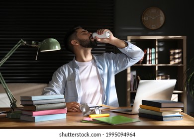 Young Man With Energy Drink Studying At Home