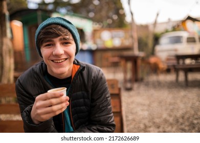 Young Man Enjoying A Delicious Coffee At An Outdoor Food Truck Stand In Patagonia, Argentina, During His Winter Vacation.