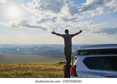 Young man enjoying a moonlit night on top of his camper van. - Powered by Shutterstock