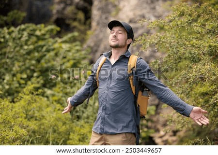 Young man enjoying nature, breathing deeply the fresh air. Let's take care of our natural surroundings and our environment. Moments of disconnection and relaxation