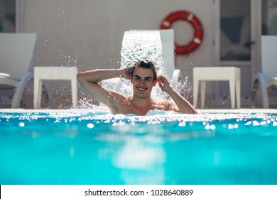 Young Man Enjoying  Pool Spa Day In Relaxing Vacation Resort.Pampered Man,metro Sexual,caring For Body And Well Being.Hydro Massage For Neck Pain.Relaxing Under Water Jet,neck And Spine Massage.