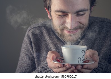 Young Man Enjoying The Smell Of His Hot Beverage, Tea Or Coffee, Anticipating The Sweet Taste