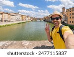 Young man enjoys beautiful view on famous Old bridge in Florence, sitting back on the riverside at sunset. man traveler visiting italian landmarks. travel concept